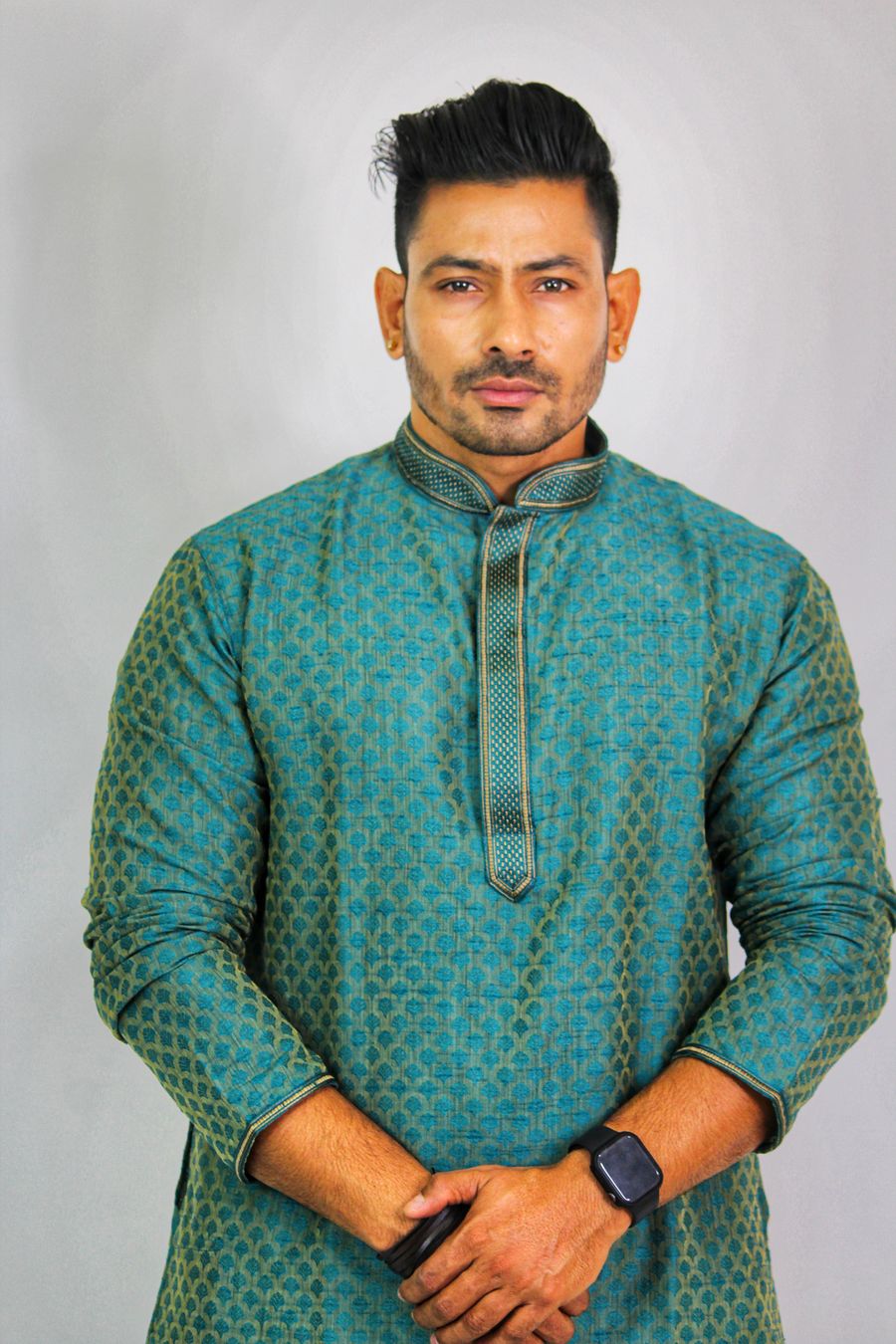 Studio portrait of a man in a teal embroidered kurta