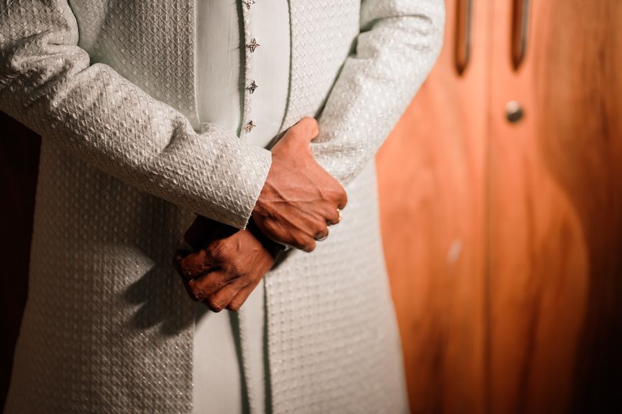 Close-up of hands and embroidered sleeve detail on a kurta