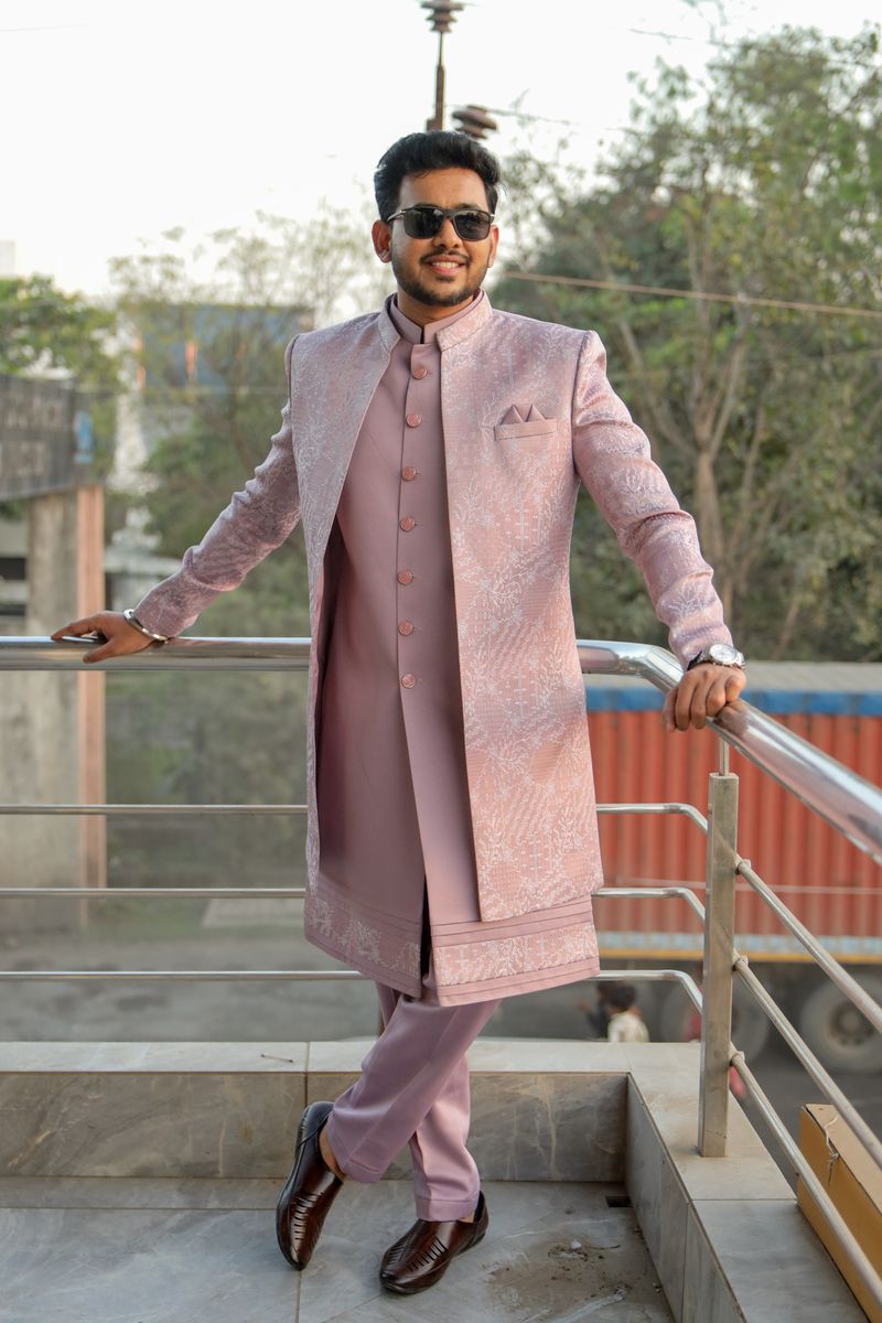 Young man in a blush pink kurta set and sunglasses