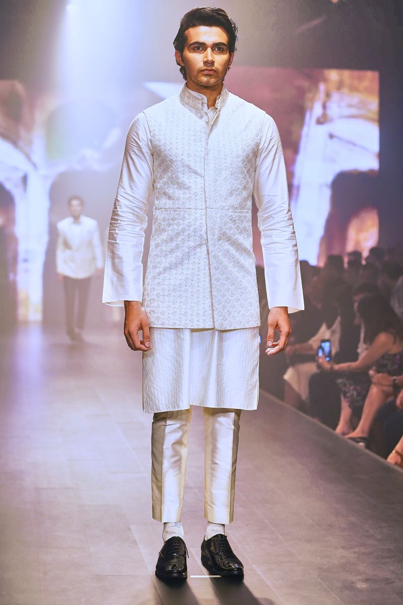 Model walking in a white embroidered kurta set