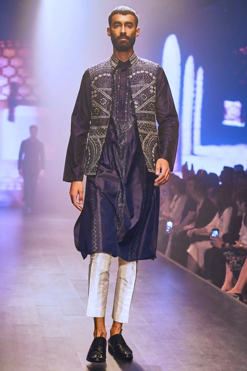 Model walking in a black embroidered kurta
