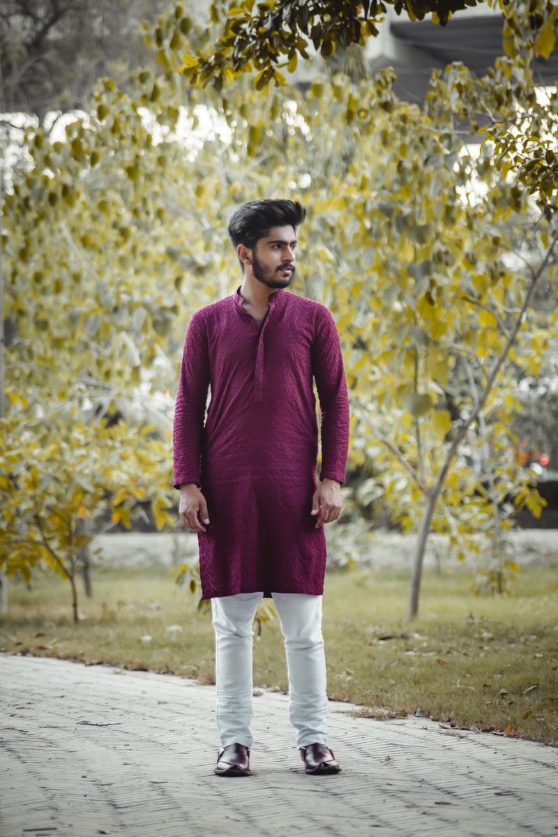 Man in a maroon cotton kurta walking in autumn light
