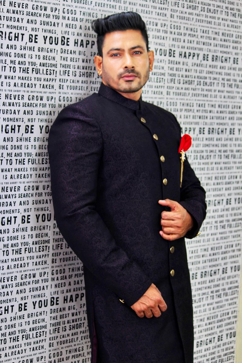Man in a black bandhgala with a red rose